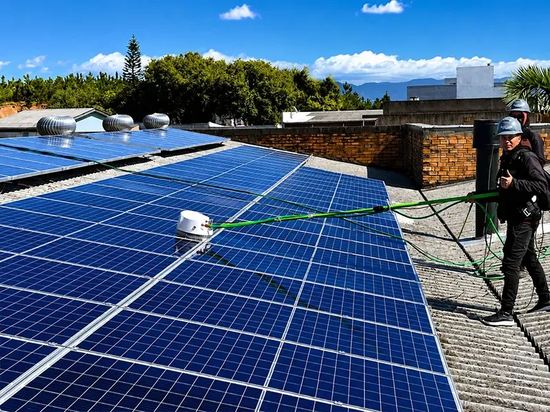 Técnico da Litoral limpando painéis solares em um telhado